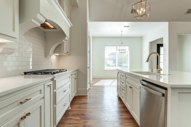 kitchen with appliances with stainless steel finishes, sink, a notable chandelier, and decorative light fixtures