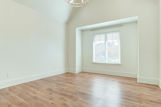 spare room featuring high vaulted ceiling and light hardwood / wood-style floors