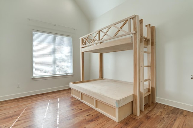 unfurnished bedroom featuring lofted ceiling and hardwood / wood-style floors