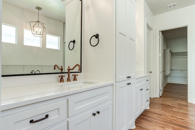 bathroom with hardwood / wood-style flooring, vanity, and a chandelier