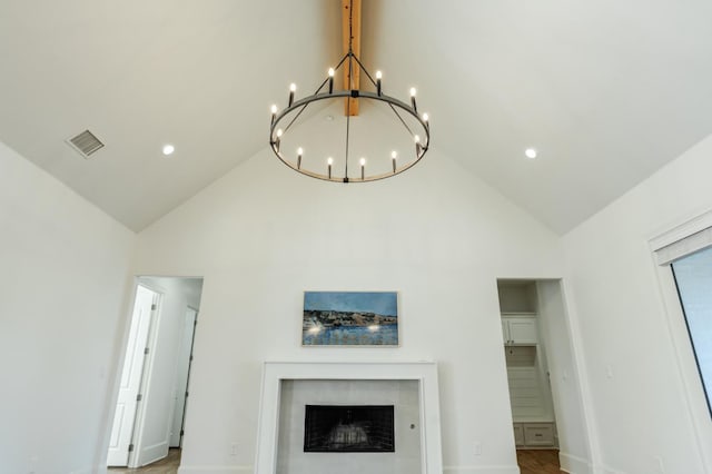 details featuring a tiled fireplace and an inviting chandelier