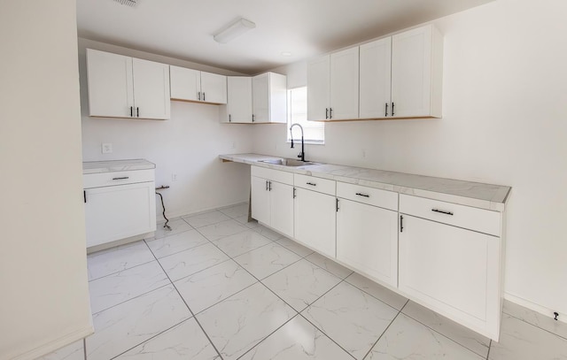 kitchen featuring sink and white cabinets