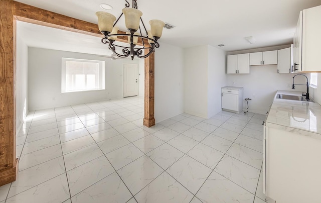 2004 Date Ave, Lubbock, TX 79404 - unfurnished dining area featuring beamed ceiling, sink, and a notable chandelier