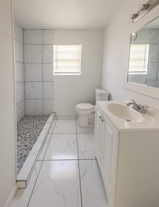 2004 Date Ave, Lubbock, TX 79404 - bathroom featuring vanity, plenty of natural light, a tile shower, and toilet