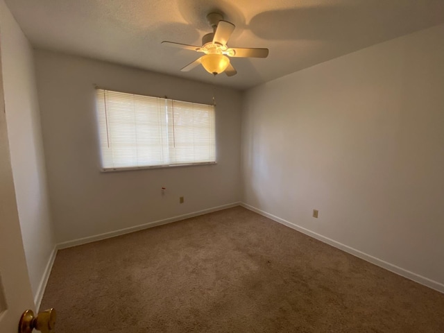 spare room with carpet floors and ceiling fan