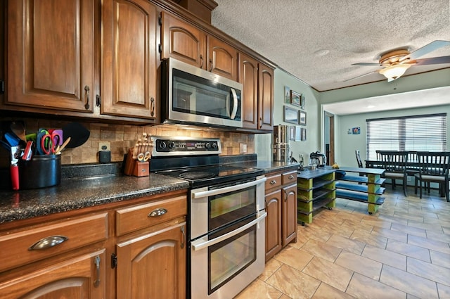 kitchen with decorative backsplash, stainless steel appliances, ceiling fan, and a textured ceiling