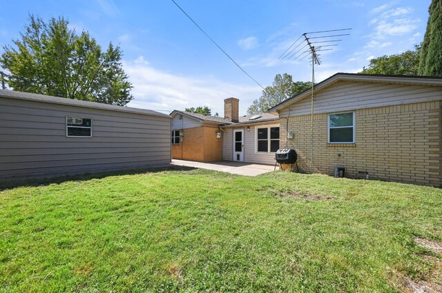 back of property with a yard and a patio