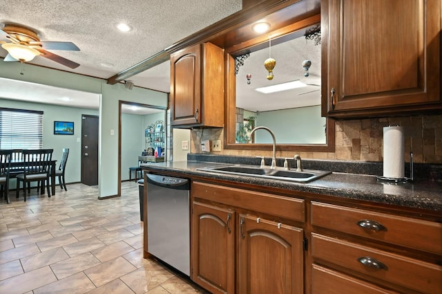 kitchen featuring dishwasher, sink, decorative backsplash, and a textured ceiling