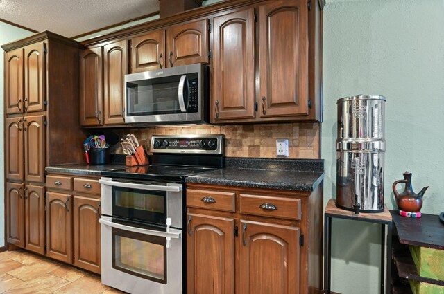 kitchen with tasteful backsplash, wine cooler, and appliances with stainless steel finishes