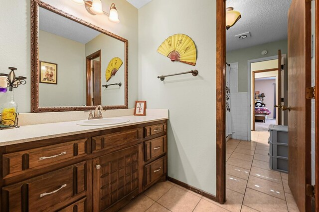 bathroom featuring vanity, tile patterned flooring, tile walls, and a textured ceiling