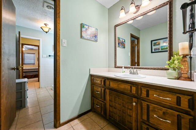 bathroom featuring vanity, tile walls, tile patterned floors, and a textured ceiling