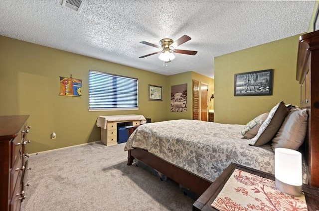 carpeted bedroom with ceiling fan and a textured ceiling