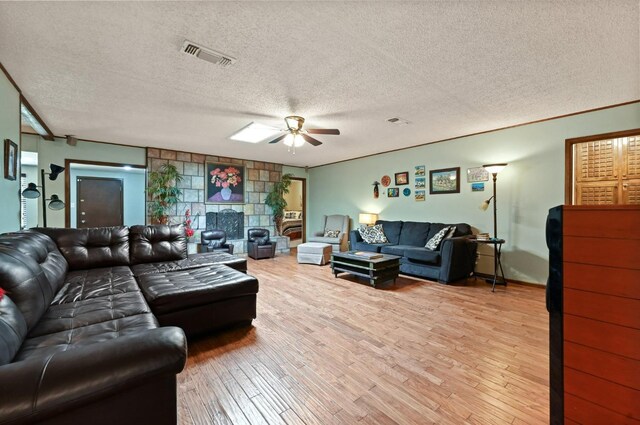 living room with ceiling fan, crown molding, light hardwood / wood-style floors, and a textured ceiling