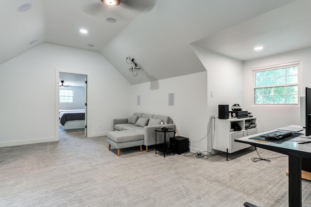 home office featuring lofted ceiling, ceiling fan, light carpet, and baseboards