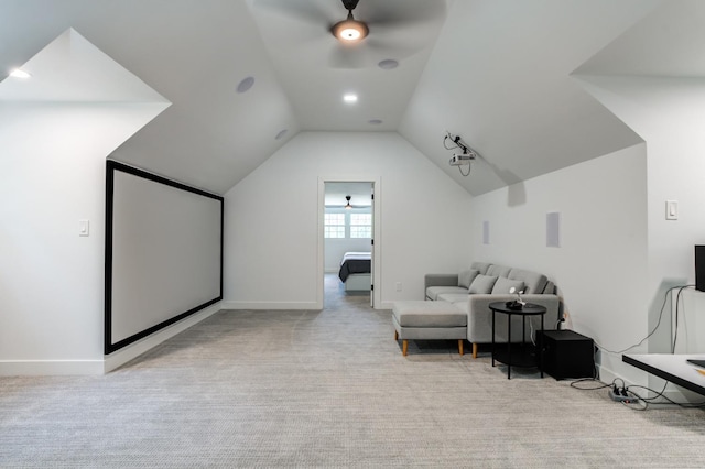 cinema room featuring vaulted ceiling, light carpet, ceiling fan, and baseboards