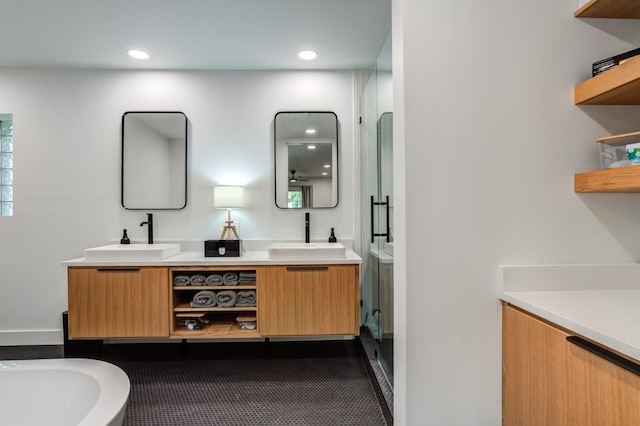 bathroom featuring a freestanding bath, double vanity, a sink, and a shower stall