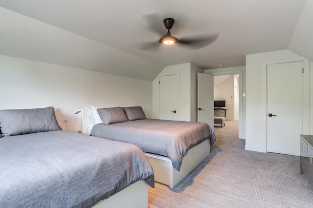 bedroom with vaulted ceiling, ceiling fan, and light carpet