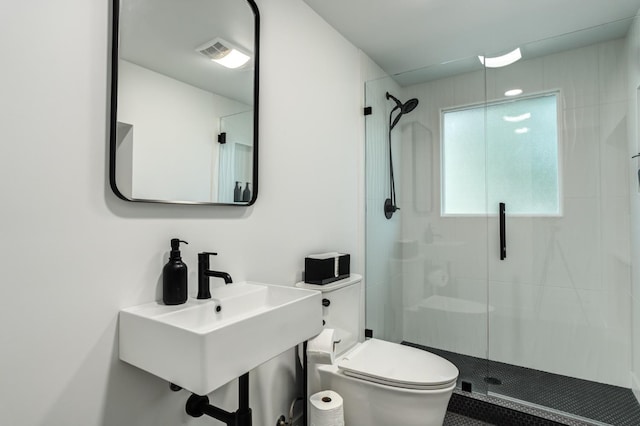 bathroom featuring a stall shower, a sink, and toilet