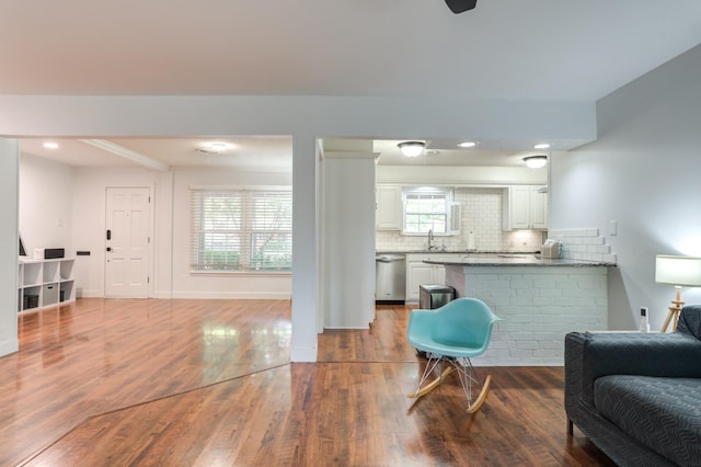 living area with baseboards and wood finished floors