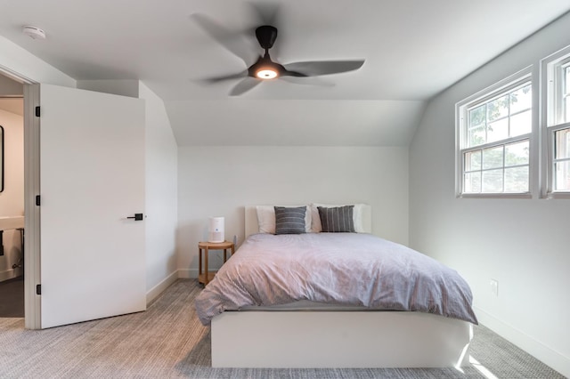 bedroom featuring a ceiling fan, lofted ceiling, light carpet, and baseboards