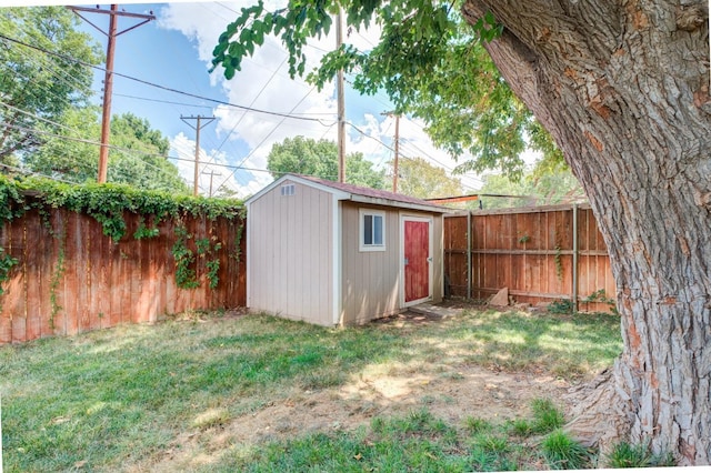 view of yard with an outbuilding, a fenced backyard, and a shed