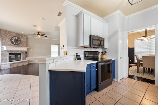 10827 Detroit Ave, Lubbock, TX 79423 - kitchen with appliances with stainless steel finishes, blue cabinets, light tile patterned floors, ornamental molding, and a ceiling fan