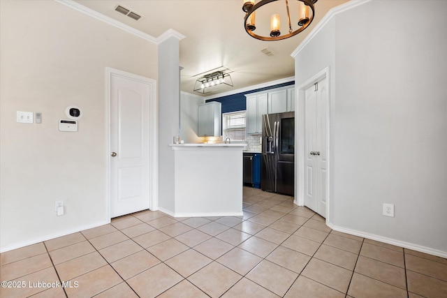 10827 Detroit Ave, Lubbock, TX 79423 - kitchen with stainless steel fridge, light countertops, a chandelier, decorative backsplash, and light tile patterned floors