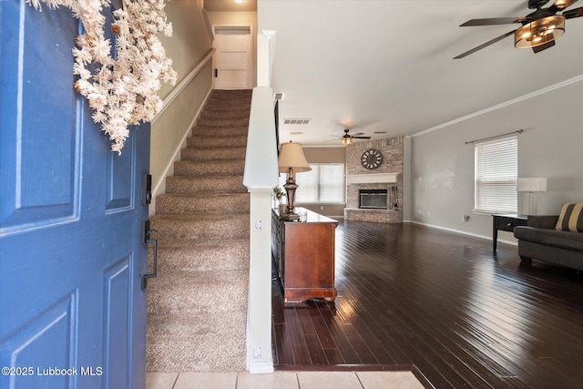10827 Detroit Ave, Lubbock, TX 79423 - entrance foyer featuring ceiling fan, stairs, hardwood / wood-style flooring, ornamental molding, and a brick fireplace