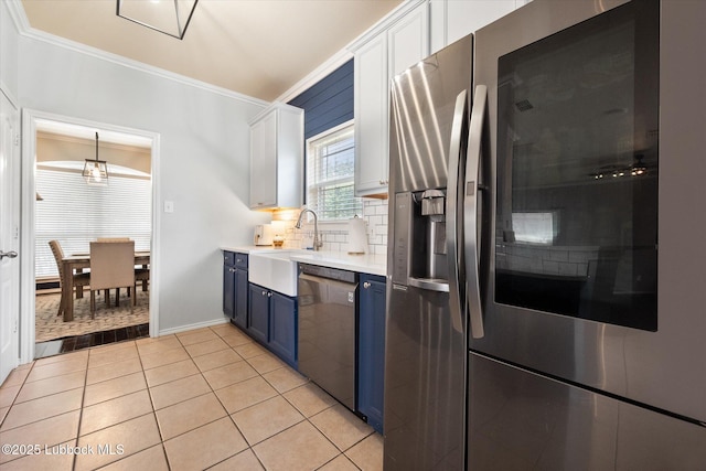 10827 Detroit Ave, Lubbock, TX 79423 - kitchen with appliances with stainless steel finishes, blue cabinets, crown molding, a sink, and light countertops