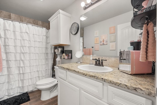 bathroom featuring wood finished floors, toilet, vanity, and a shower with curtain