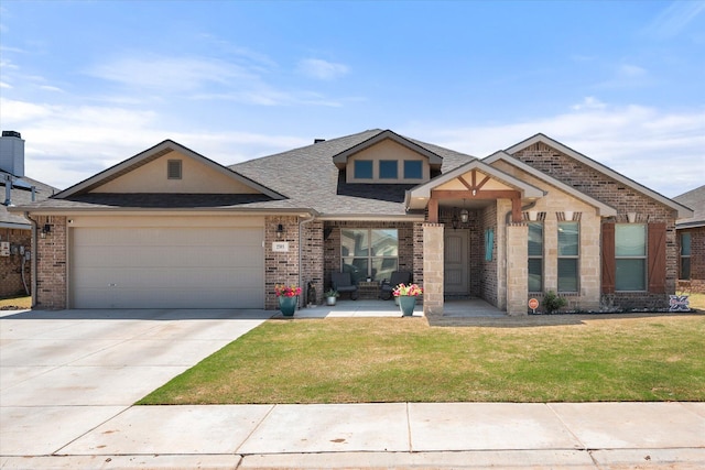 craftsman-style home featuring an attached garage, driveway, brick siding, and a front yard