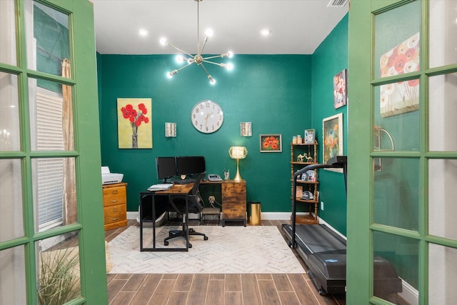 office featuring a chandelier, wood finished floors, visible vents, and baseboards