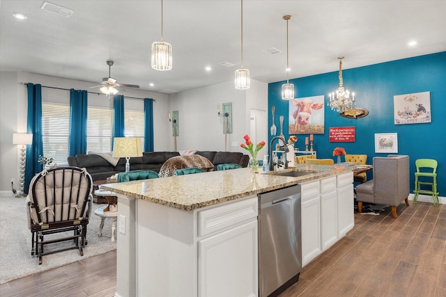 kitchen featuring stainless steel dishwasher, wood finished floors, a sink, open floor plan, and visible vents
