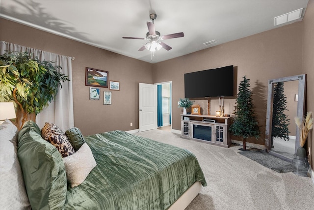 bedroom featuring ceiling fan, visible vents, baseboards, and light carpet