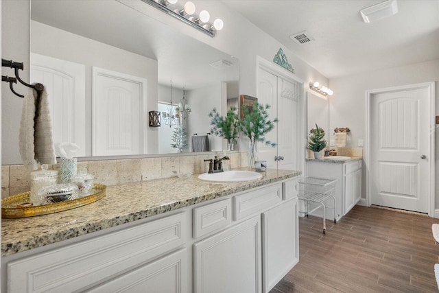 full bath featuring wood finished floors, visible vents, and vanity