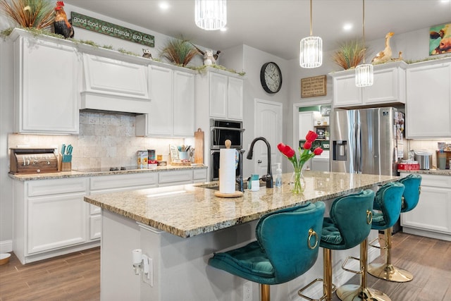 kitchen featuring backsplash, wood finished floors, stainless steel appliances, and a sink
