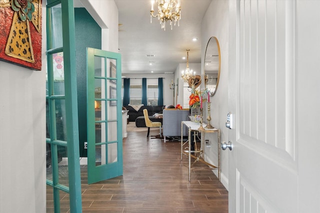 entrance foyer with french doors, a chandelier, and dark wood finished floors