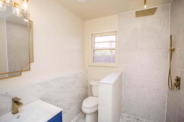 bathroom featuring toilet, vanity, a walk in shower, and tile walls