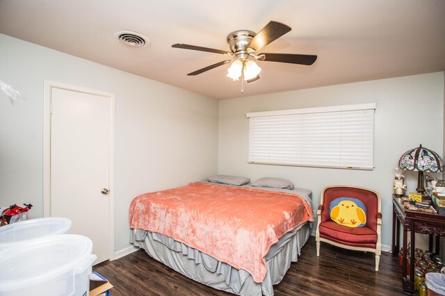 bedroom featuring baseboards, visible vents, dark wood-style floors, and ceiling fan