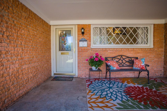property entrance with brick siding and a porch