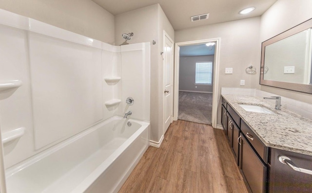 bathroom with vanity, wood-type flooring, and  shower combination