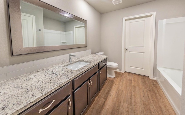 bathroom featuring wood-type flooring, vanity, and toilet