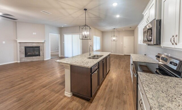 kitchen with dark brown cabinetry, stainless steel appliances, sink, and white cabinets