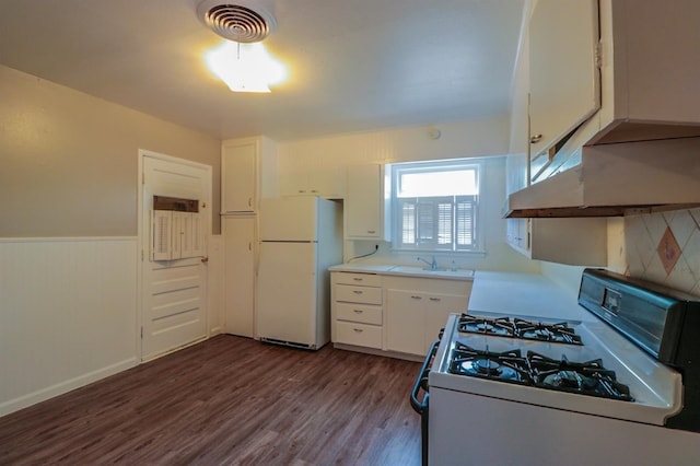 kitchen with tasteful backsplash, white cabinetry, wood-type flooring, sink, and white appliances