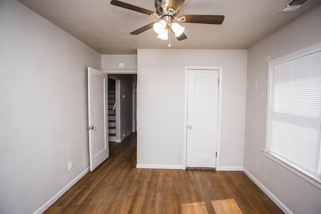 unfurnished bedroom with ceiling fan and dark hardwood / wood-style floors