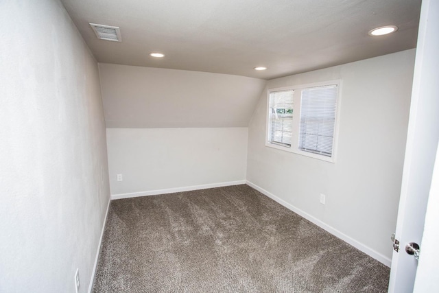 bonus room with carpet flooring and vaulted ceiling