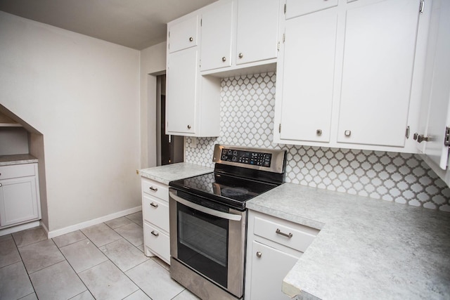 kitchen with white cabinetry, light tile patterned floors, tasteful backsplash, and electric range