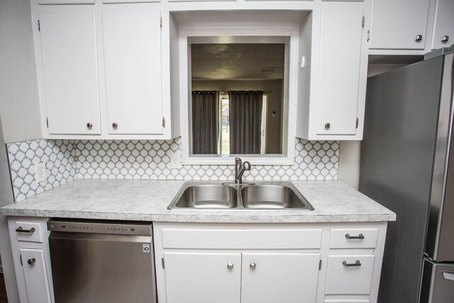 kitchen featuring white cabinetry, sink, backsplash, and stainless steel appliances