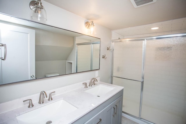 bathroom with toilet, vanity, and walk in shower