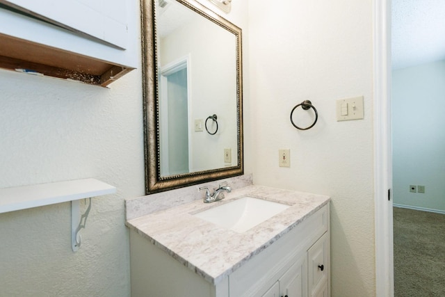 bathroom with vanity and a textured wall